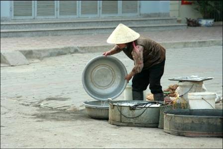 Woman washing dishes in Hanoi