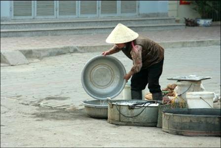 Woman washing dishes in Hanoi Woman washing dishes in Hanoi