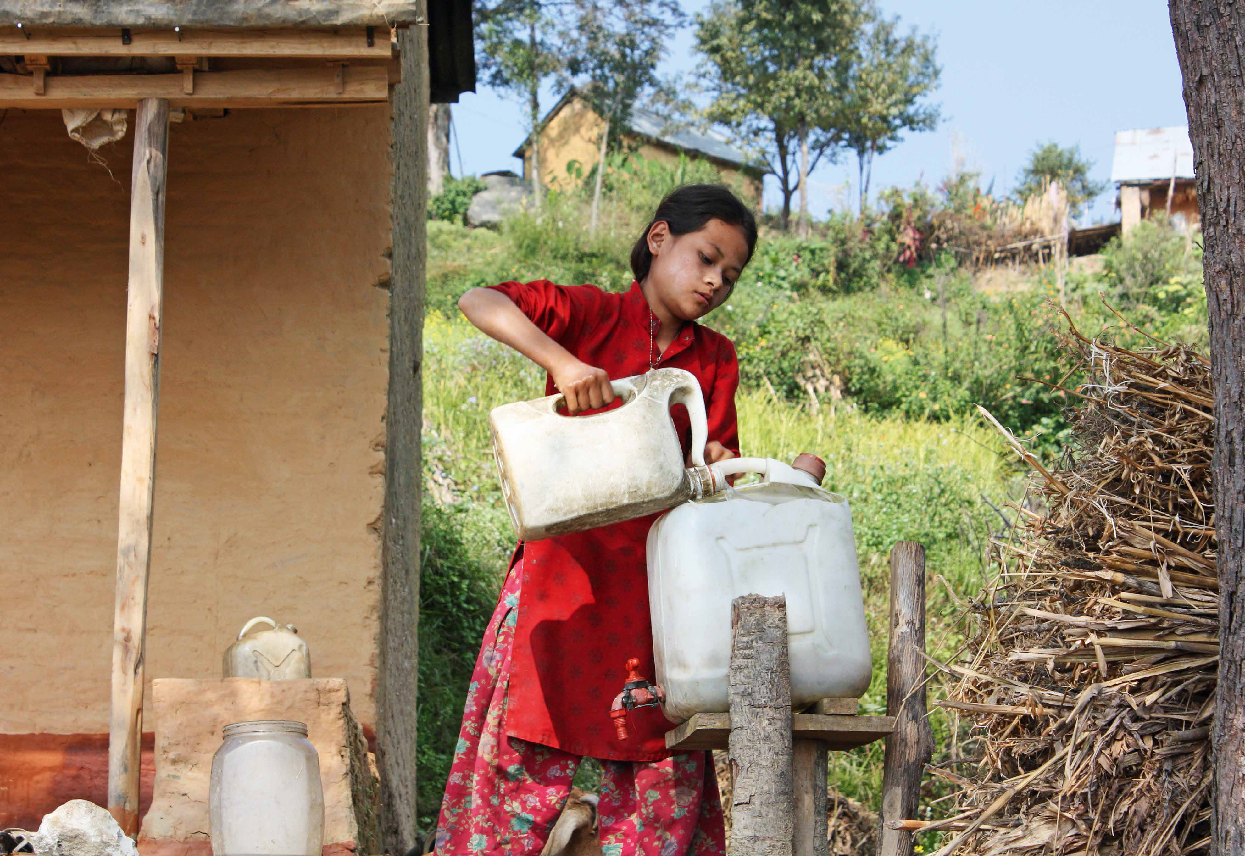 Mädchen in Bangladesch füllt Wasser in einen Kanister © UFZ