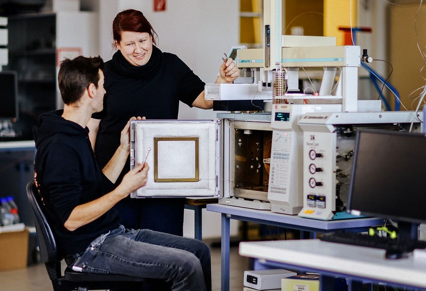 Zwei Personen vor einem technischen Ger&auml;t, die sich dar&uuml;ber unterhalten und sich anschauen. Foto: Anne Schwerin