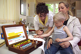 Klinik-Schwester Annett Bergner mit einem Kindergartenkind beim Prick-Test