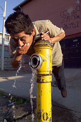 Mann trinkt Trinwasser aus Hydranten in Santiago de Chile