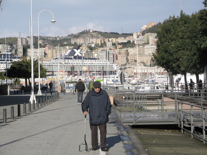 Genoa: old man having a walk in the renovated ancient port area Genoa: old man having a walk in the renovated ancient port area