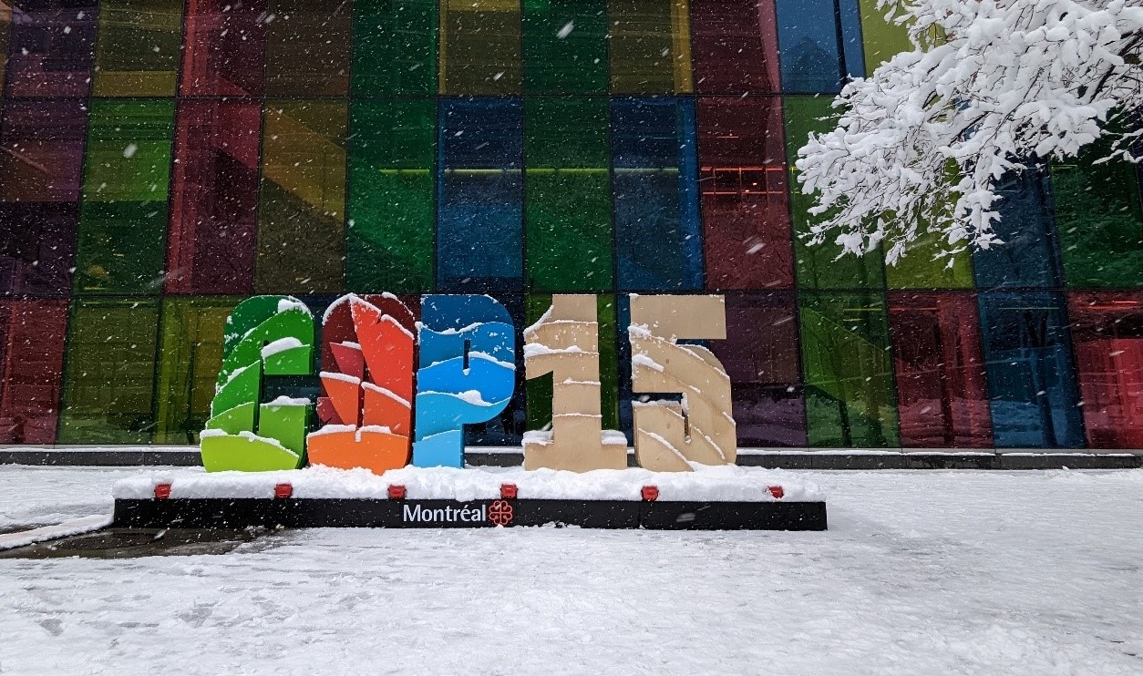 Menschengroße Buchstaben "COP-15" im Schnee vor einem Gebäude in Montreal