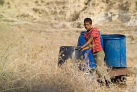 Junge mit Wasserbehältern im Nahen Osten